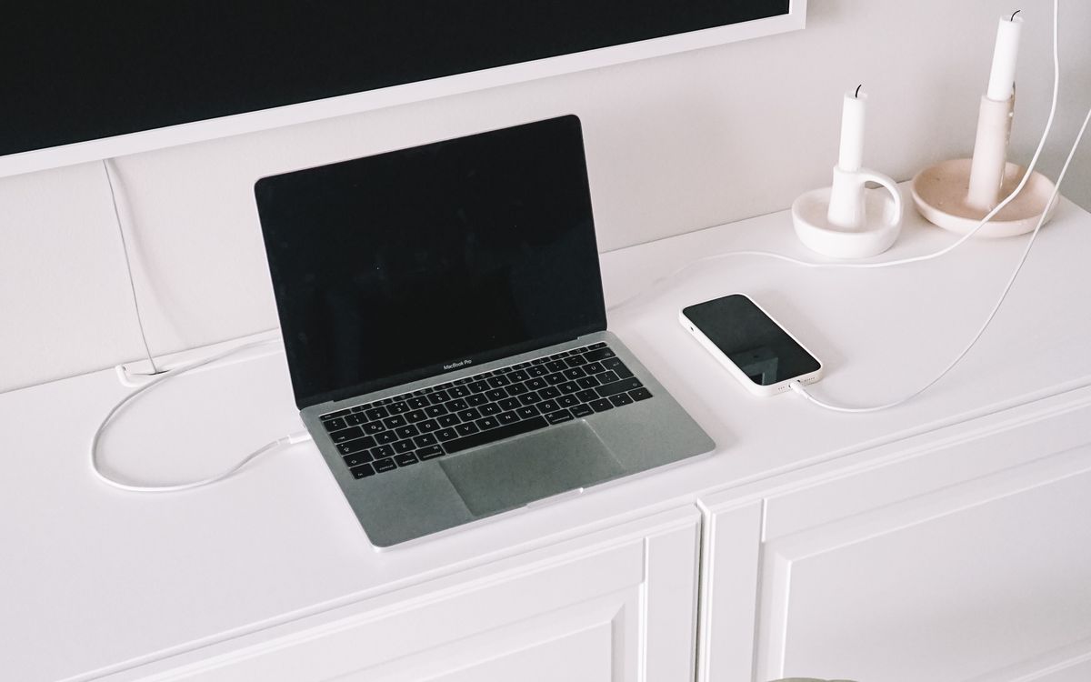 A minimalist home workspace with a laptop and television